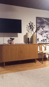 a flat screen tv sitting on top of a wooden cabinet at St Moritz Suite in St. Moritz