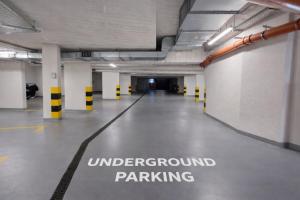 an empty parking garage with a underground parking sign on the floor at InPoint Central Apartments Old Town&Kazimierz - Free Parking in Krakow