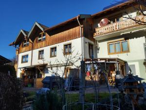a large white house with a wooden roof at Ferienwohnung Renate in Siegsdorf