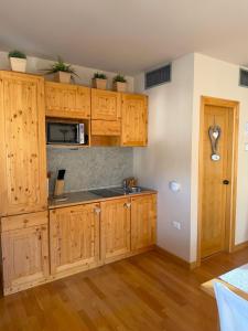 a kitchen with wooden cabinets and a microwave at Bormio Alpine Home in Bormio