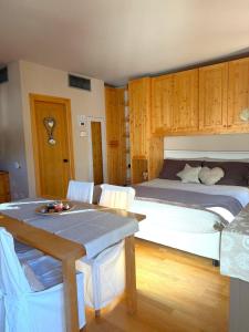 a bedroom with a large bed and a table at Bormio Alpine Home in Bormio