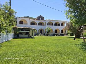 a large white building with a grass yard at Santa Maria in Vitalades