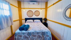 a bedroom with a bed with blue pillows on it at Casa da Barra Tutóia in Tutóia