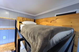 a bedroom with a large bed with a wooden headboard at AJL Hospedagem Container in Curitiba