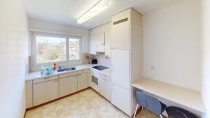 a kitchen with white cabinets and a window at Functional Stay with Balcony in Zurich
