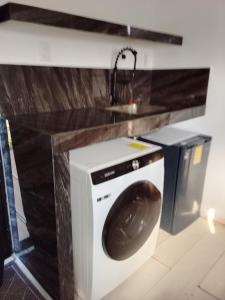 a washing machine in a kitchen with a sink at Container House in Sisal