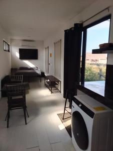 a living room with a tv and a room with a bed at Container House in Sisal