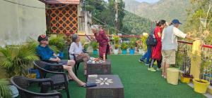 a group of people standing and sitting on a balcony at Sangam View Homestay Devprayag in Devaprayāg