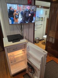 a refrigerator with its door open in a room with a tv at Peniche Saul Nomad in Aigues-Mortes