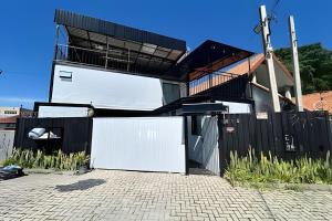 a house with a white refrigerator in front of a fence at AJL Hospedagem Container in Curitiba