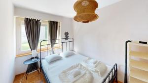 a bedroom with a bed with white sheets and a window at Functional Stay with Balcony in Zurich
