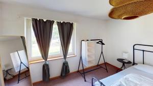 a bedroom with a window with curtains and a mirror at Functional Stay with Balcony in Zurich +5 photos