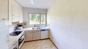 a kitchen with white cabinets and a window at Functional Stay with Balcony in Zurich