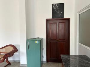 a room with a green refrigerator and a wooden door at Hikka Residence 98 in Hikkaduwa