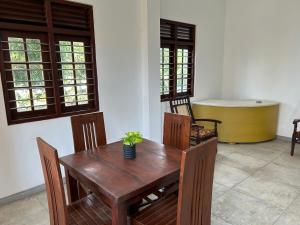 a dining room with a wooden table and chairs at Hikka Residence 98 in Hikkaduwa