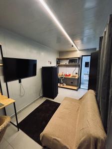 a living room with a couch and a tv in a room at AJL Hospedagem Container in Curitiba