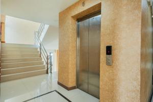 a metal elevator in a building with stairs at ZAYN Bangna Hotel in Bangna