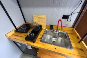 a kitchen with a sink in a tiny house at AJL Hospedagem Container in Curitiba +84 photos