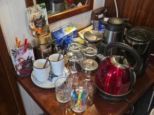 a counter with cups and glasses and a tea kettle at Peniche Saul Nomad in Aigues-Mortes