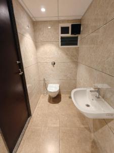 a bathroom with a toilet and a sink at Neelram Hospitality in Mangalore