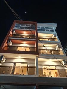 a tall building at night with lights on it at Neelram Hospitality in Mangalore