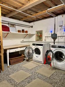 a laundry room with a washer and a washing machine at Waterfall Views-Stylish Design-Big Comfy Bed in Lauterbrunnen