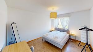 a bedroom with a bed and a table in a room at Practical Apartment Near Seebach in Zurich