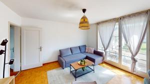 a living room with a blue couch and a table at Practical Apartment Near Seebach in Zurich