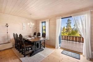 a dining room with a table and chairs and a window at Marits Hytte 6p in Vradal +24 photos