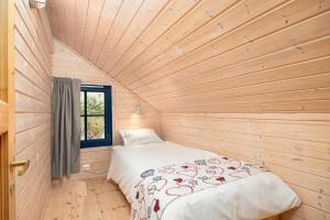 a bed in a room with a wooden ceiling at Marits Hytte 6p in Vradal