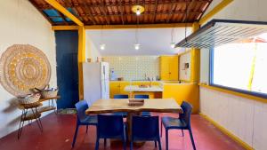 a kitchen with a wooden table and blue chairs at Casa da Barra Tutóia in Tutóia