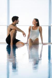 a man and a woman sitting in the water at Vestlia Resort in Geilo