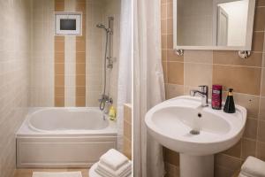 a bathroom with a sink and a bath tub with a shower at 5 minute from Airport Baku in Bina