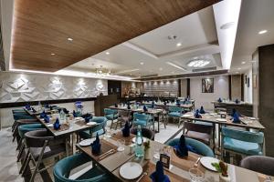 a restaurant with tables and chairs in a room at Hotel Suba Star Ahmedabad in Ahmedabad