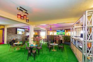 a restaurant with tables and chairs and green carpet at The VIP Luxury CBD in Kisumu