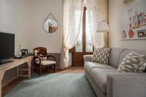 a living room with a couch and a table with a television at Albergo Le Terme in Bagno Vignoni