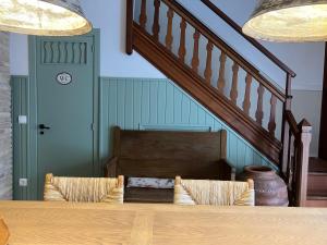 a dining room table with two chairs and a staircase at L' Alzina in Falset