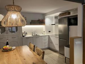 a kitchen with a wooden table and a refrigerator at L' Alzina in Falset