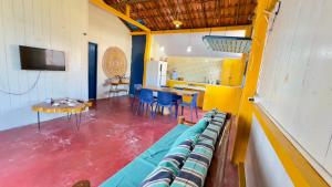a room with chairs and a table and a kitchen at Casa da Barra Tutóia in Tutóia