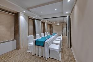 a conference room with a long table and white chairs at Hotel Suba Star Ahmedabad in Ahmedabad