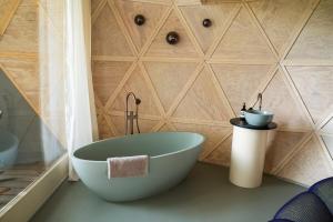 a bath tub in a bathroom with a wall at Echo - Baumhaus K1 in Odenthal