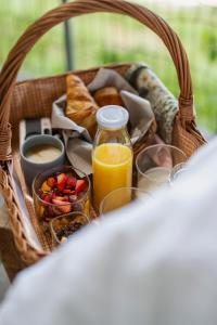 a basket of food with a basket of bread and orange juice at Echo - Baumhaus K1 in Odenthal