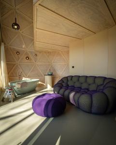 a bathroom with a couch and a sink and a tub at Echo - Baumhaus K1 in Odenthal