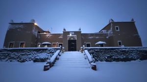 a building covered in snow with stairs in front at Kasbah Restaurant Citoyenne in Agoudal