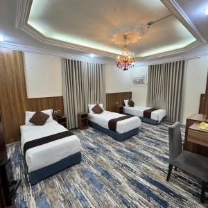 a hotel room with two beds and a chandelier at بيت سلسبيل- salsbil house in Medina