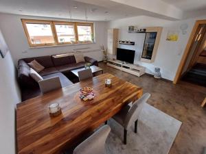 a living room with a wooden table and a couch at Ferienwohnung Bergtroll in Uderns
