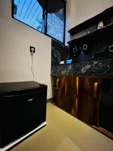 a room with a counter with a television on a wall at Ancy Villa in Dickwella +4 photos