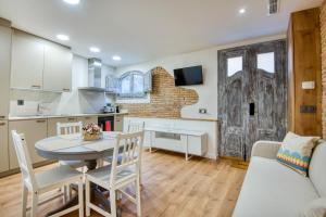 a kitchen and living room with a table and chairs at Pati Blau 2 in Caldes de Malavella