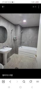 a bathroom with a tub and a sink and a bath tub at 벨라지오호텔 in Sagog-yŏk