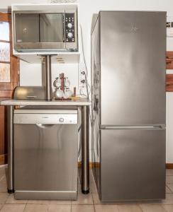 a kitchen with a stainless steel refrigerator and a microwave at Estuary Cottage in Sedgefield